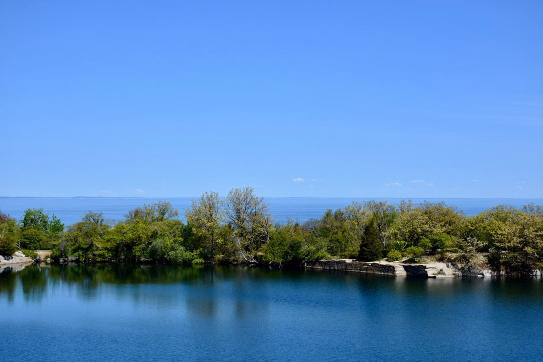 Quarry water and shrubs in front of the open ocean at Halibut Point State Park