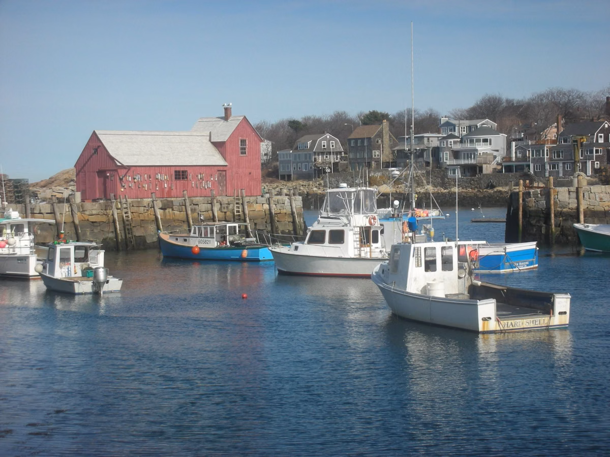 Motif No. 1, the red fishing shack on a Rockport wharf, with lobster boats in the harbor