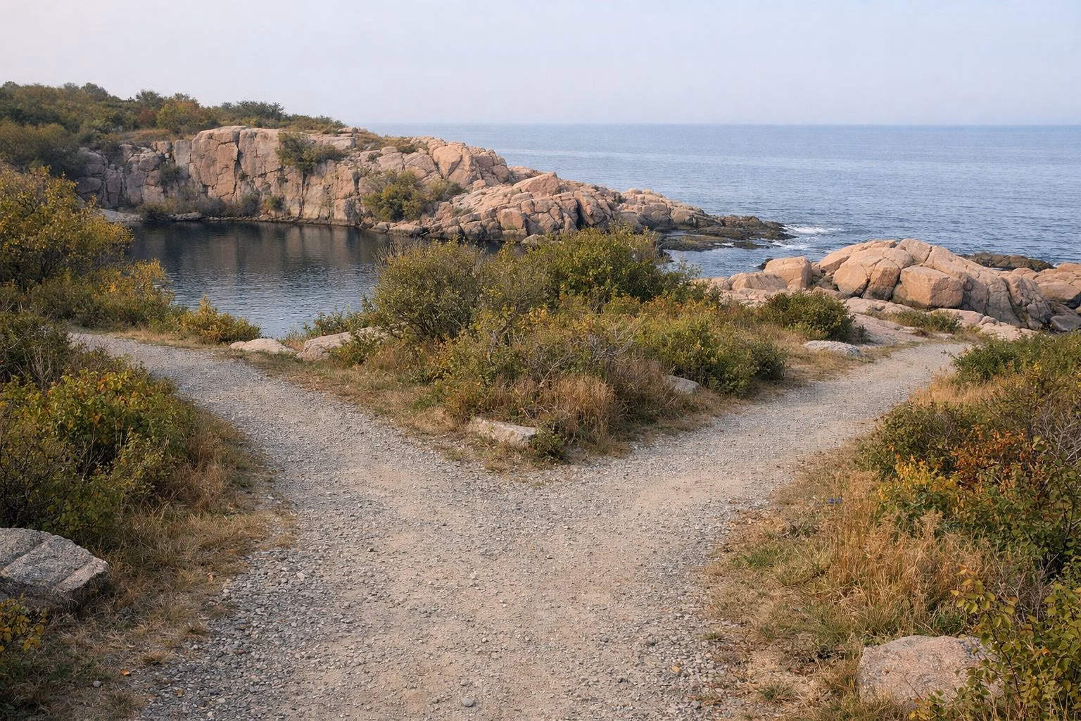 A fork in the trail with a quarry pool and the ocean beyond